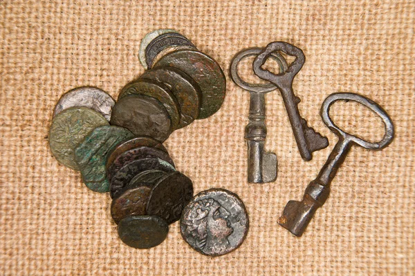 Oude munten met portretten van koningen en sleutels op de oude clot — Stockfoto