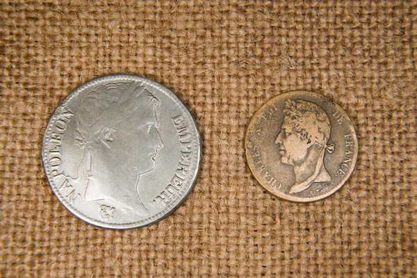 Monedas antiguas con retratos de reyes sobre el viejo paño — Foto de Stock