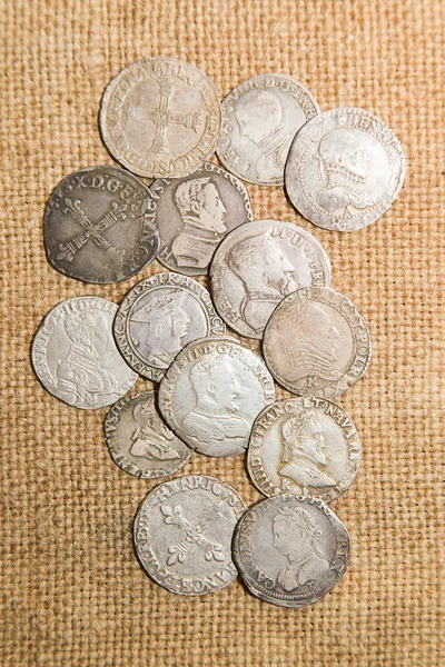 Oude munten met portretten van koningen op de oude doek — Stockfoto