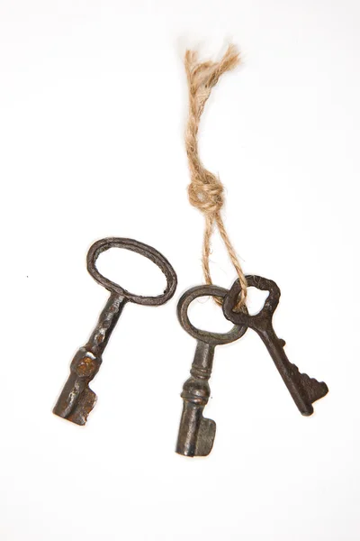 A lot vintage keys on a rope on white background — Stock Photo, Image