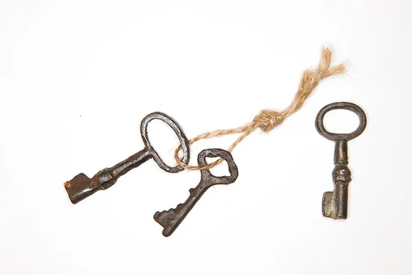 A lot vintage keys on a rope on white background — Stock Photo, Image