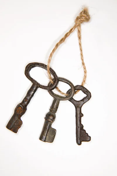 A lot vintage keys on a rope on white background — Stock Photo, Image