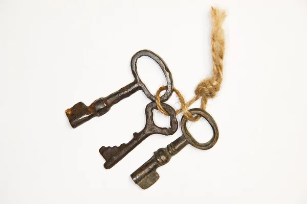 A lot vintage keys on a rope on a white background — Stock Photo, Image