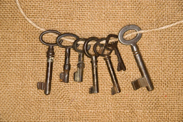 A lot vintage keys from the locks on old cloth — Stock Photo, Image