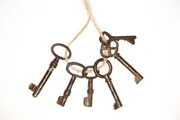 A lot vintage keys on a rope on white background — Stock Photo, Image