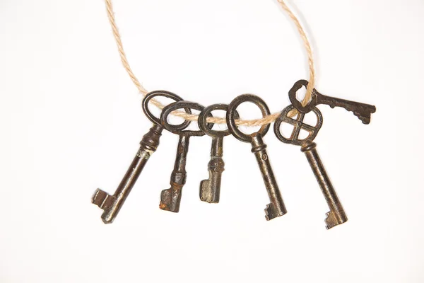 A lot vintage keys on a rope on white background — Stock Photo, Image