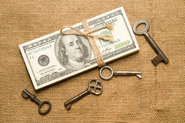 One pack of dollars and keys on an old cloth — Stock Photo, Image