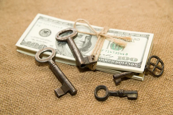 Eine Packung Dollars und Schlüssel auf einem alten Tuch — Stockfoto