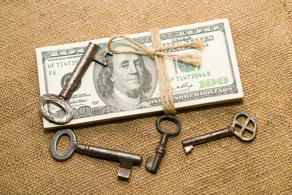 One pack of dollars and keys on an old cloth — Stock Photo, Image