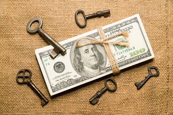 One pack of dollars and keys on an old cloth — Stock Photo, Image