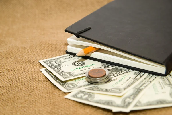 Notebook, lápis e dinheiro no tecido velho — Fotografia de Stock
