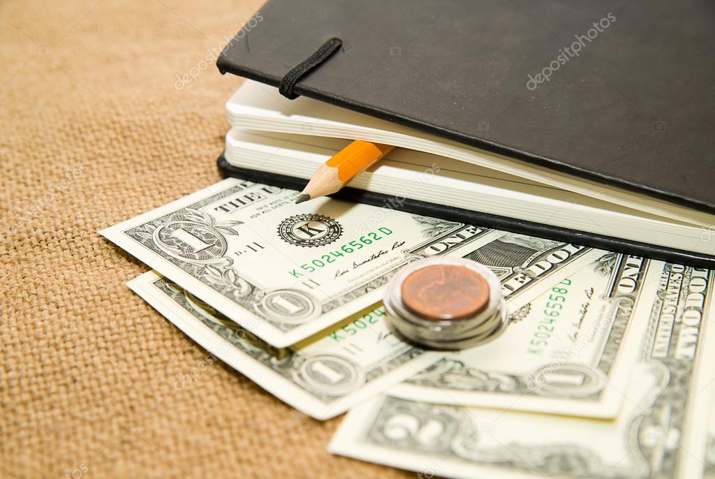 notebook, money and pencil on the old tissue