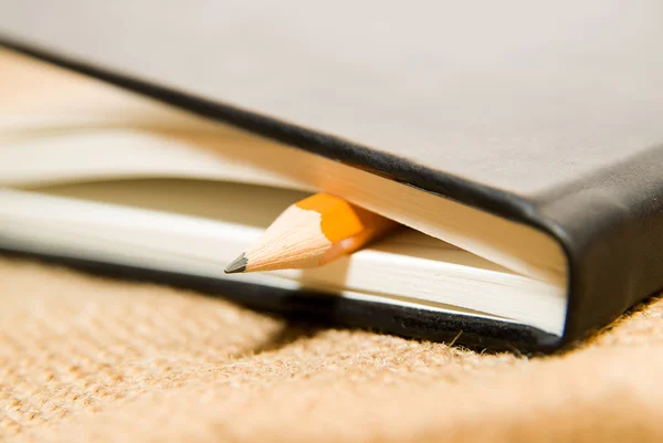 Notebook and pencil on the old tissue — Stock Photo, Image