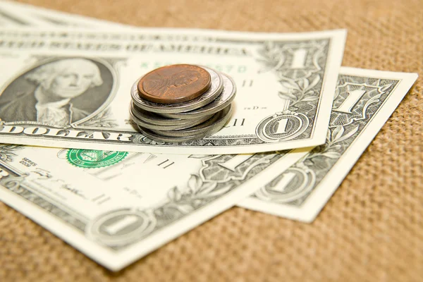Dollarnoten und Münzen auf altem Tuch — Stockfoto