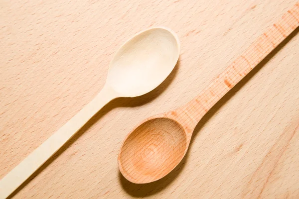 Two wooden spoons of different colors on the surface — Stock Photo, Image