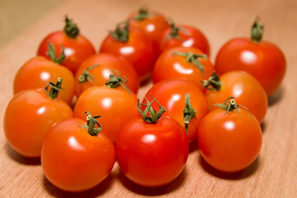 Tomates rojos sobre una superficie de madera — Foto de Stock