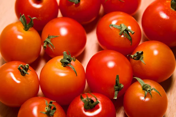 Tomates rojos maduros sobre una superficie de madera — Foto de Stock