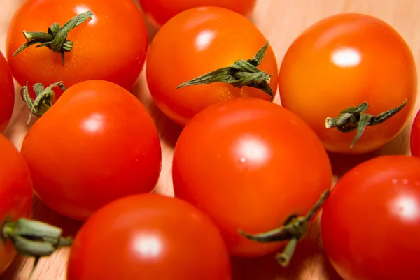 Tomates rojos maduros sobre una superficie de madera — Foto de Stock