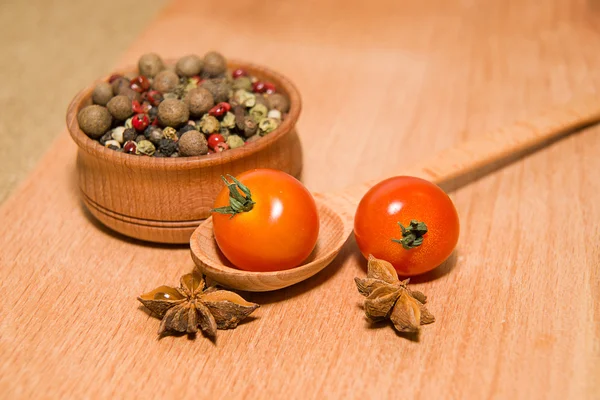 Tomates rojos en cuchara, pimienta y anís estrellado — Foto de Stock