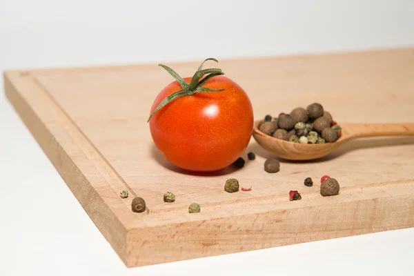 Red tomatoes, spoon, pepper on a white background — Stock Photo, Image