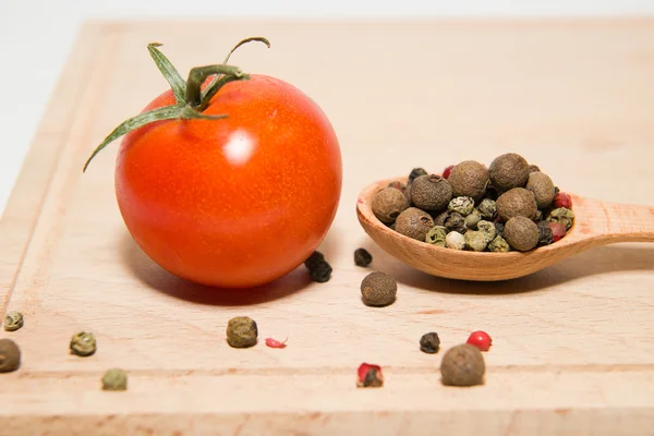 Red tomatoes, spoon, pepper on a white background — Stock Photo, Image