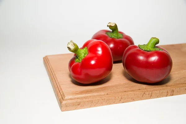 Três pimentas vermelhas maduras sobre branco — Fotografia de Stock