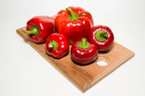 Muchos pimientos rojos maduros sobre blanco — Foto de Stock