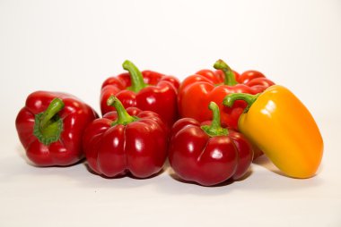 Birçok olgun kırmızı ve sarı biber üzerinde beyaz üzerinde