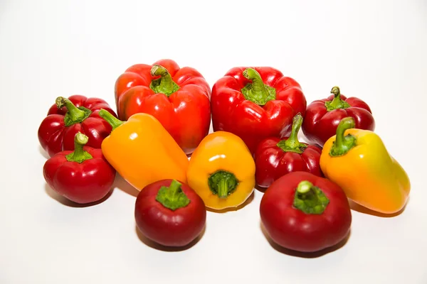 Many ripe red and yellow peppers on over white — Stock Photo, Image