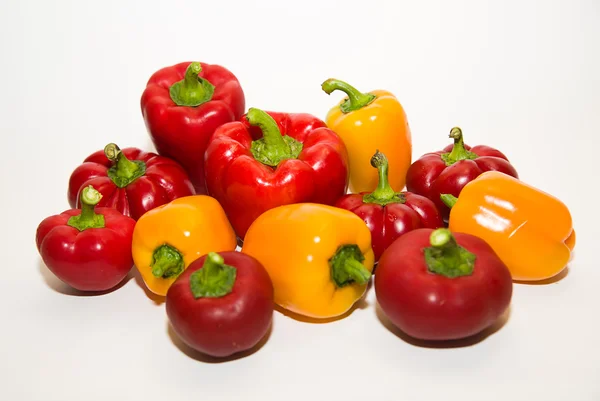 Many ripe red and yellow peppers on over white — Stock Photo, Image