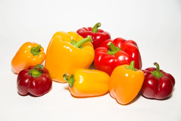 Muitos pimentos vermelhos e amarelos maduros sobre branco — Fotografia de Stock