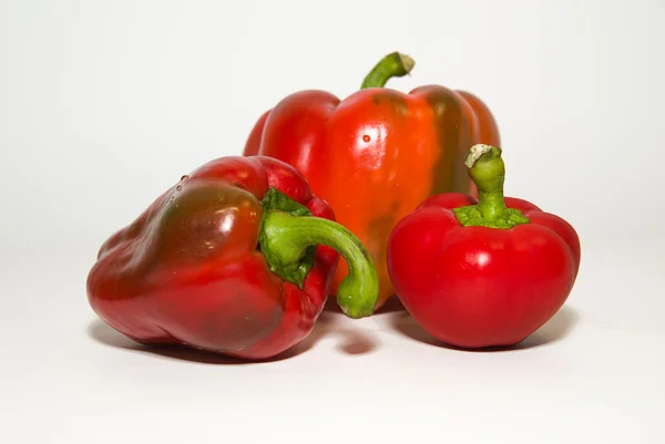 Três pimentas vermelhas maduras sobre branco — Fotografia de Stock