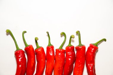 Birçok olgun kırmızı biber üzerinde beyaz üzerinde