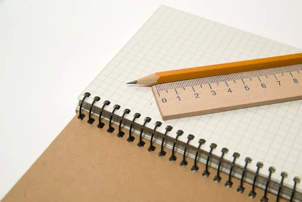 Açılan not defteri, kalemi ve beyaz üzerinde üzerinde ahşap rulerl — Stok fotoğraf