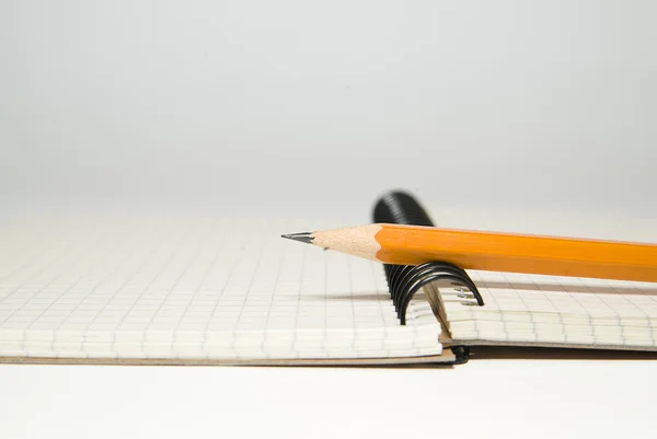 Открытая тетрадь и карандаш поверх белого — стоковое фото