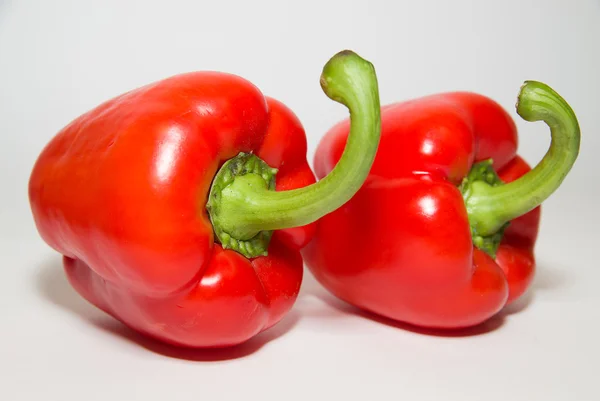 Dois pimentos vermelhos maduros sobre branco — Fotografia de Stock