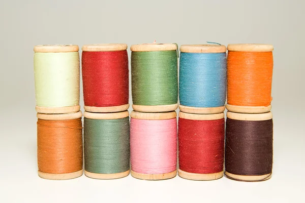 Many spools of thread of different colors on a white — Stock Photo, Image
