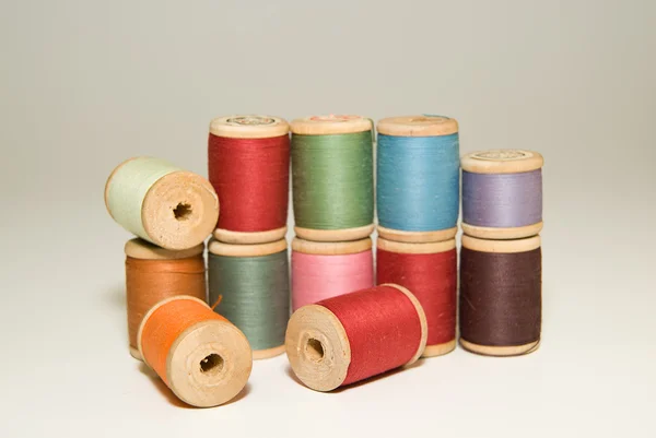 Many spools of thread of different colors on a white — Stock Photo, Image