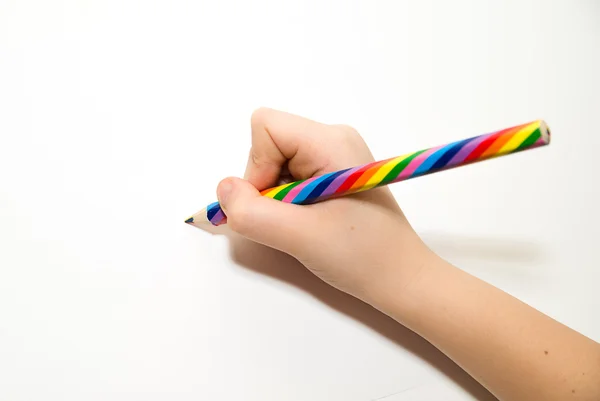 Kinderhand, die einen Bleistift über Weiß hält — Stockfoto
