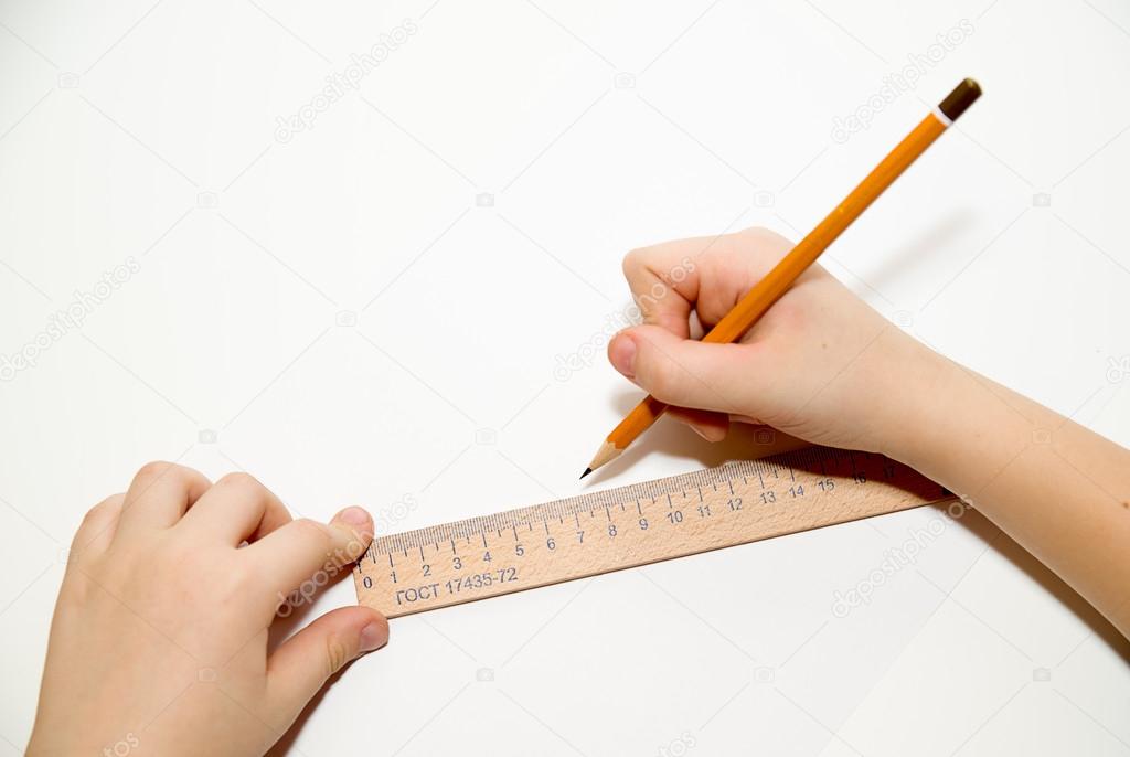Kid's  hands holding a pencil on over white