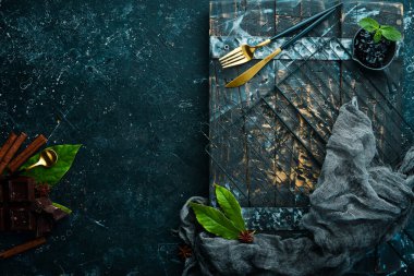 Mutfak siyah arka planda mutfak aletleri ve baharatlar. Üst Manzara. Kırsal biçim.