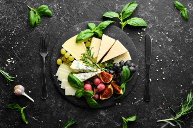 Tabakta çeşitli peynirler var. Parmesan peyniri, mavi peynir ve üzümlü ve incirli peynir. Antipasto. Üst görünüm.