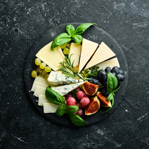 プレートにチーズを盛り付けます パルメザンチーズ ブルーチーズ ブドウやイチジクとプレート上のブリー 反パスト トップ表示 — ストック写真