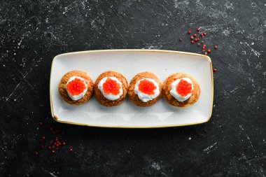 Soğuk atıştırmalıklar. Peynirli pasta ve kırmızı havyar. Havyarlı sandviç. Üst Manzara. Metin için boş alan.