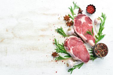 Beyaz bir masada baharatlı, sulu çiğ biftek. Pirzola bifteği. Üst Manzara. Metnin için boş yer.