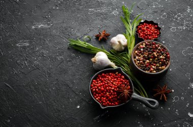 Karanlık bir arka planda çeşitli biber ve baharatlar. Üst Manzara. Metnin için boş yer.