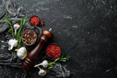 Karanlık bir arka planda çeşitli biber ve baharatlar. Üst Manzara. Metnin için boş yer.