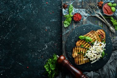 Yiyecekler. Fırında patlıcan, mavi peynirli ve fesleğenli siyah taş tabakta. Üst Manzara. Metnin için boş yer.