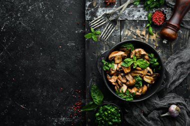 Yiyecekler. Siyah taş tabakta fesleğenli ızgara mantar. Üst Manzara. Metnin için boş yer.