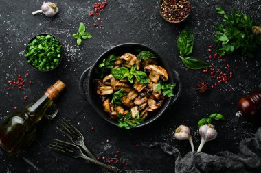 Yiyecekler. Siyah taş tabakta fesleğenli ızgara mantar. Üst Manzara. Metnin için boş yer.